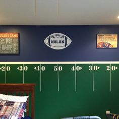 a bedroom with a football wall decal on the wall