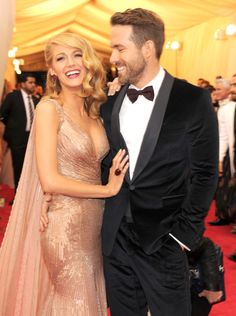 a man in a tuxedo standing next to a woman on a red carpet