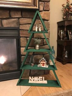 a christmas tree made out of wooden shelves in front of a fireplace