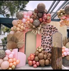 a bunch of balloons that are hanging on a wall in the shape of a house