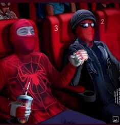 two people in red shirts and black pants sitting next to each other with masks on