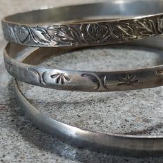 :DETAILS: Lot of 3 vintage silver tone bangles.  They are all unmarked and appear to be alloy. There is some brassiness on the inside of all three. The pricing reflects age, condition, presumed metal content.  One is plain. Another has flowers and leaves, and the third has a Taxco type pattern.  :SHIPS: Same/next day for free. Vintage Silver Stackable Cuff Bracelet, Vintage Silver Stackable Bangle, Nickel-free Vintage Round Bangle, Nickel-free Vintage Bangle, Vintage Nickel-free Round Bangle, Bangle Set, Metal Stamping, Vintage Silver, Cute Jewelry