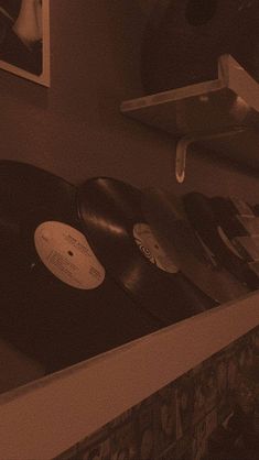 an old record player sitting on top of a shelf next to a wall mounted clock