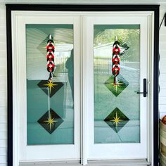 two glass doors with christmas decorations on them