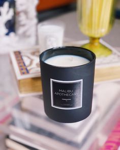 a candle sitting on top of a table next to books