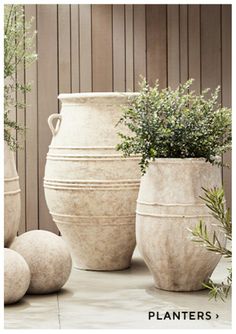 three large vases sitting next to each other on a table