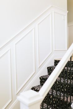 the stairs are lined with black and white polka dot fabric, along with decorative wallpaper