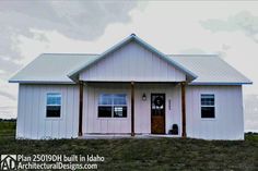 a white house with two windows and a door on the front porch is standing in a grassy field