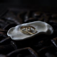 two wedding rings sitting on top of a shell