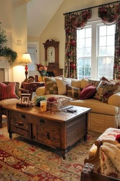 a living room filled with furniture and a fire place next to a large window covered in curtains