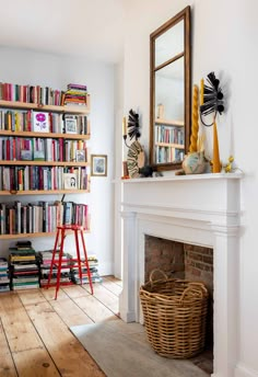 a living room with a fire place and bookshelf full of different types of books