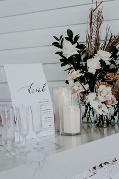 a table with candles, flowers and cards on it for guests to sign their names