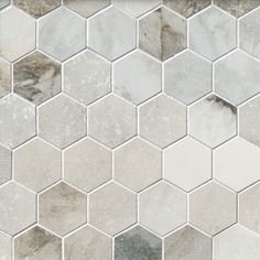 a white and grey hexagonal tile pattern on a wall with no other tiles