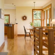 a dining room and kitchen area with wood floors