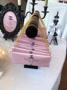 a table topped with pink and gold items on top of a white cloth covered table