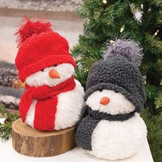 two snowmen sitting next to each other in front of a christmas tree