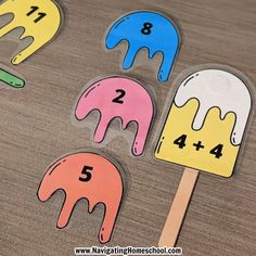 four popsicles with numbers on them sitting on a wooden table next to each other