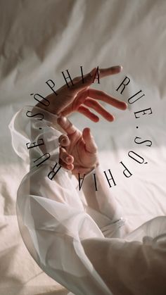 a person's hand reaching out from under a white sheet