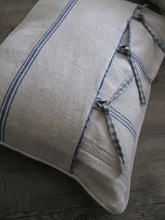 a close up of a pillow on a wooden floor with a blue and white stripe