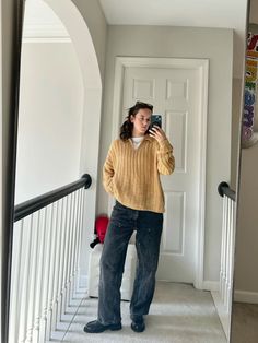 a woman taking a selfie in front of a door with her cell phone up to her ear