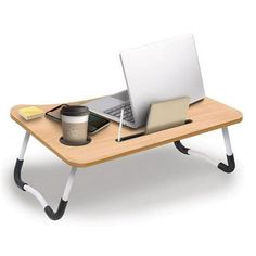 a laptop computer sitting on top of a wooden desk next to a cup of coffee