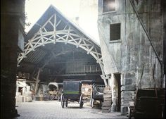 an old building with two trucks parked in front of it