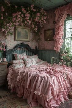 a bed with pink ruffled bedspread and pillows next to a large window