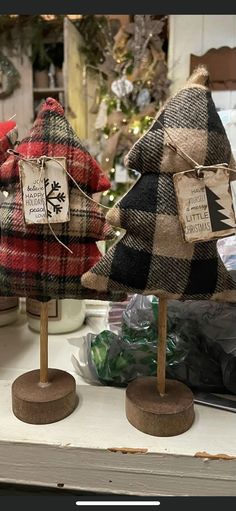 two plaid christmas trees are on display in a store