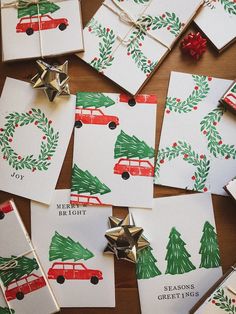 christmas cards with red car and green tree on them, surrounded by silver bells and bows