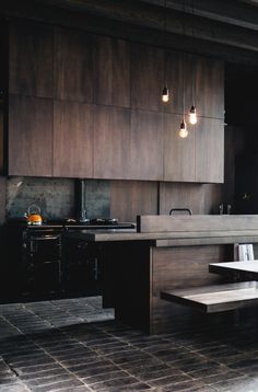 a kitchen with wooden cabinets and lights hanging from the ceiling