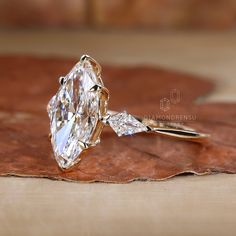 a diamond ring sitting on top of a leaf