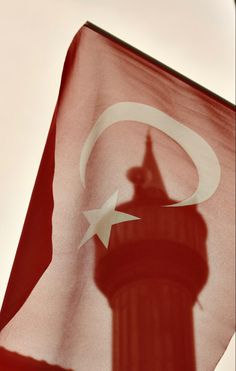 the shadow of a tower on a turkish flag