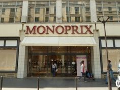 people walking in front of a store with the word monoprix on it's side