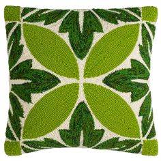 a green and white pillow with leaves on it