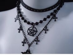 Unveil your dark, mystical allure with our Black Gothic Triple Layered Necklace. The necklace boasts a sophisticated triple-layered design, each chain meticulously crafted to fall at different lengths. The second layer is adorned with a prominent hexagram pendant. Complementing the hexagram, the third layer features cross pendants, embodying gothic influences. Black Multi-strand Layering Jewelry, Mystical Black Jewelry For Party, Black Handmade Necklace For Layering, Handmade Black Necklace For Layering, Black Gothic Chain Necklace Gift, Witchy Black Choker Necklace, Black Witchy Choker Necklace, Black Witchy Style Choker Necklace, Black Gothic Necklace With Chain