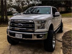 a silver truck parked on top of a driveway