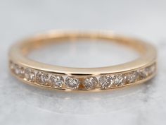 The simple lines and bright, polished gold compliment nicely with the row of diamonds channel set down the center! This can be worn as a dinner ring, right hand ring, cocktail ring, anniversary band, promise ring, alternative engagement ring... The low profile and simple shape mean it can be worn just about anywhere, anyway, with or without other rings stacked next to it!Metal: 14K Yellow Gold Gem: 12 Diamonds totaling .24 Carat, H-J in Color, SI-I in Clarity Width of Band: 2.6 mmHeight off Finger: 2.4 mmRing Size: 5Marks: "A51 14K" Stamped on the inside band Plain Gold Wedding Bands, Rings Stacked, Dinner Ring, Wedding Band Diamond, Enhancer Wedding Band, Plain Wedding Band, Right Hand Ring, Alternative Engagement Ring, Stacking Bands