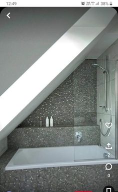 a white bath tub sitting under a slanted ceiling