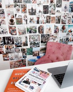 a laptop computer sitting on top of a white desk next to a wall covered with pictures