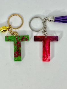 two key chains with the letter t on one side and the letter t on the other