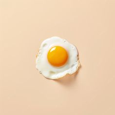 an egg is sitting in the middle of a piece of bread on a pink surface