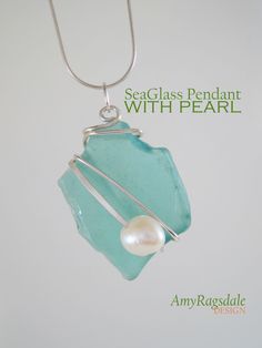 a sea glass pendant with pearl hanging from a silver chain on a white background that reads seaglass pendant with pearl