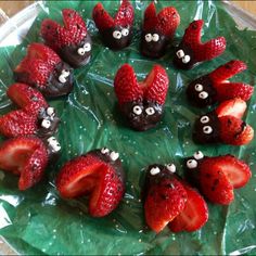 some strawberries are arranged in the shape of animals on a green leaf with googly eyes