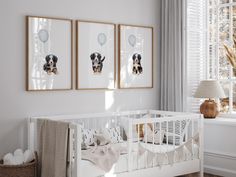 a baby's room with three framed pictures on the wall and a crib