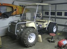 an off - road vehicle in a garage with a kayak attached to the back