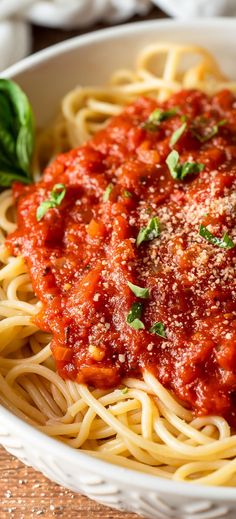 a white bowl filled with spaghetti and sauce