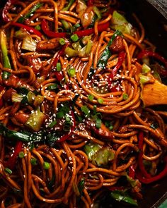 a wok filled with stir fry noodles and vegetables