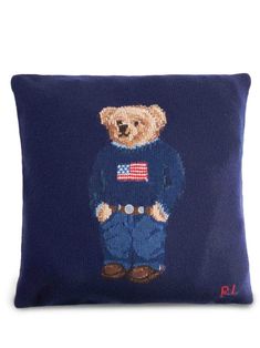 a blue pillow with a teddy bear wearing an american flag sweater on it's chest