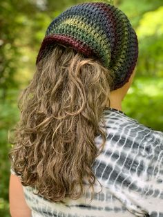 a woman with long hair wearing a multicolored crochet beanie hat