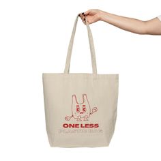 a person holding a tote bag with the words one less in red on it